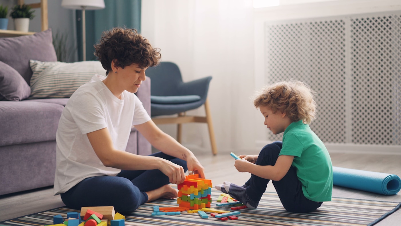 Adult and child playing with blocks during a learning activity